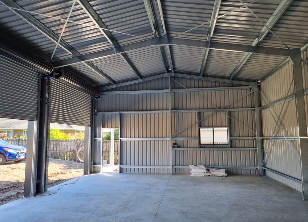 Interior of steel shed showing framing and roller door